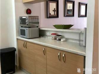 Bright living area with tall ceilings and balcony facing pool at PH Balcones Playa Blanca Panama