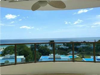 Bedroom with ceiling fan, large windows, garden views at Playa Blanca condo Panama