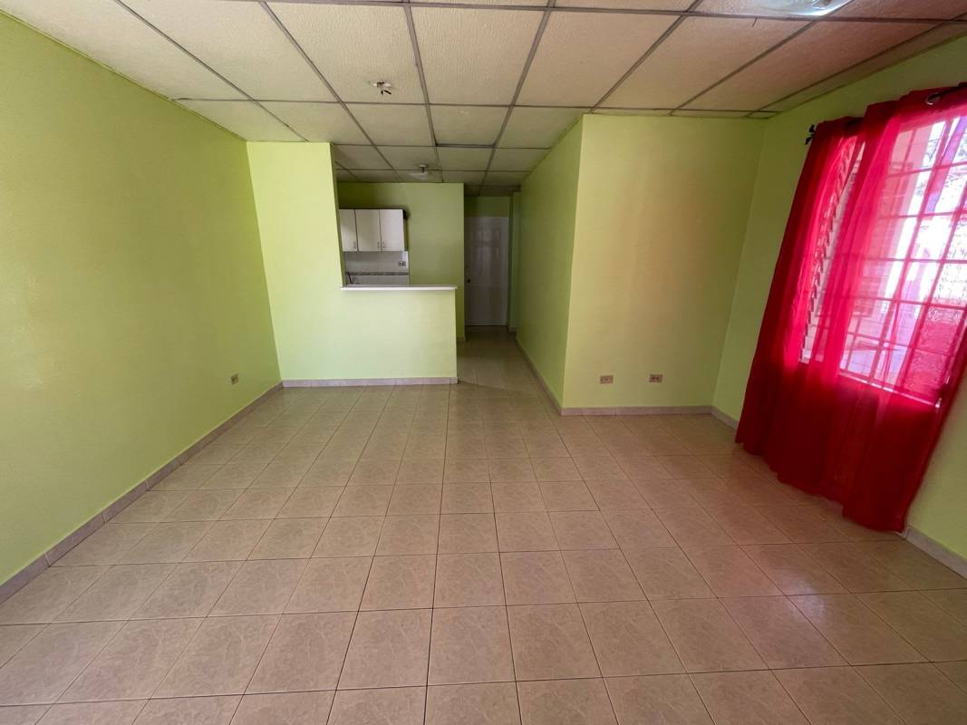 Open living room with ceramic tiles and windows in Las Acacias house for sale Panama City