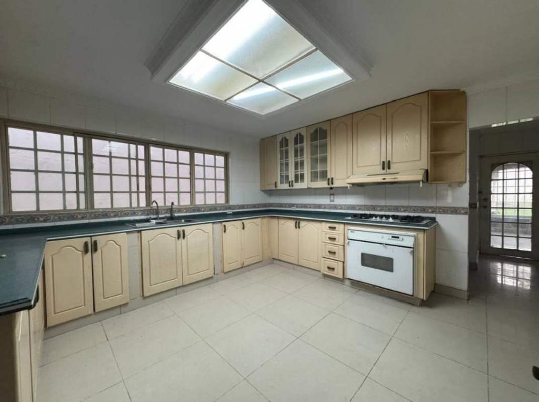 Spacious living room with tiled floor, ceiling light, window and wooden door in Altos del Chase Panama