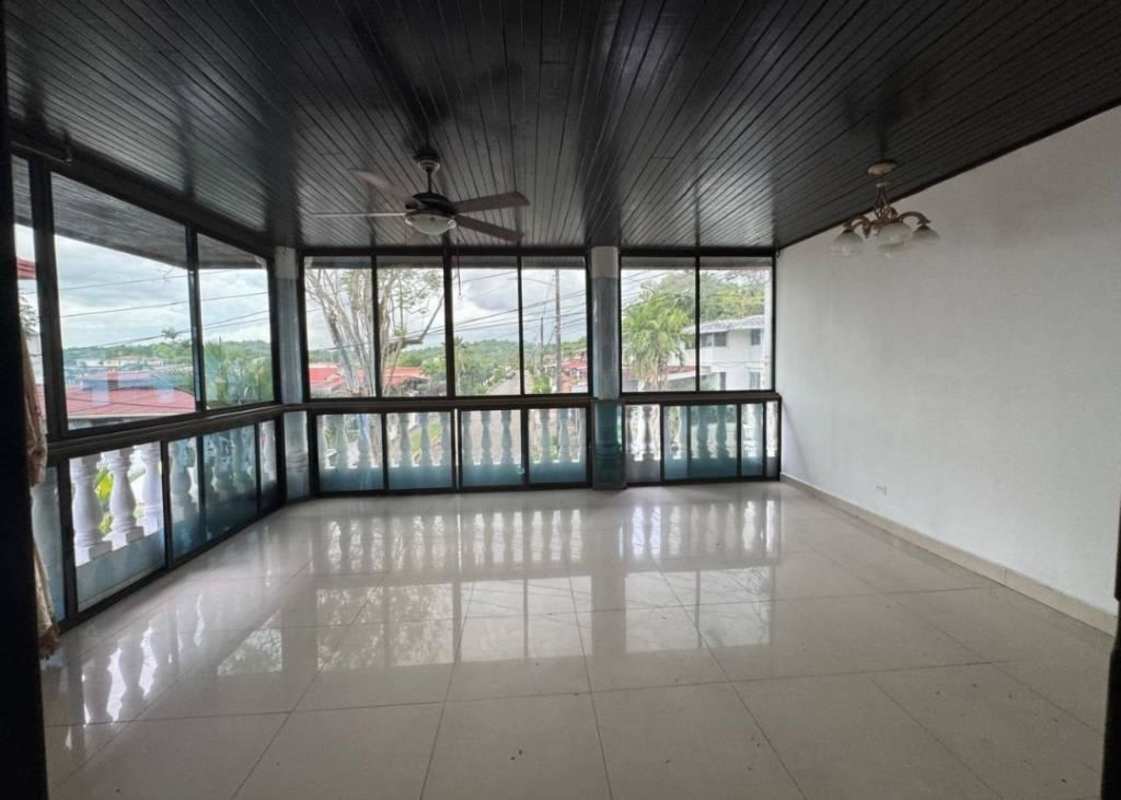 Enclosed sunroom with large windows and tile floor in residential house Altos del Chase