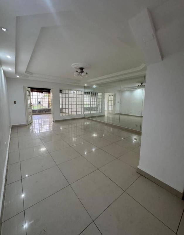 Living room with tray ceiling, split AC unit and tiled floor in house Altos del Chase Panama