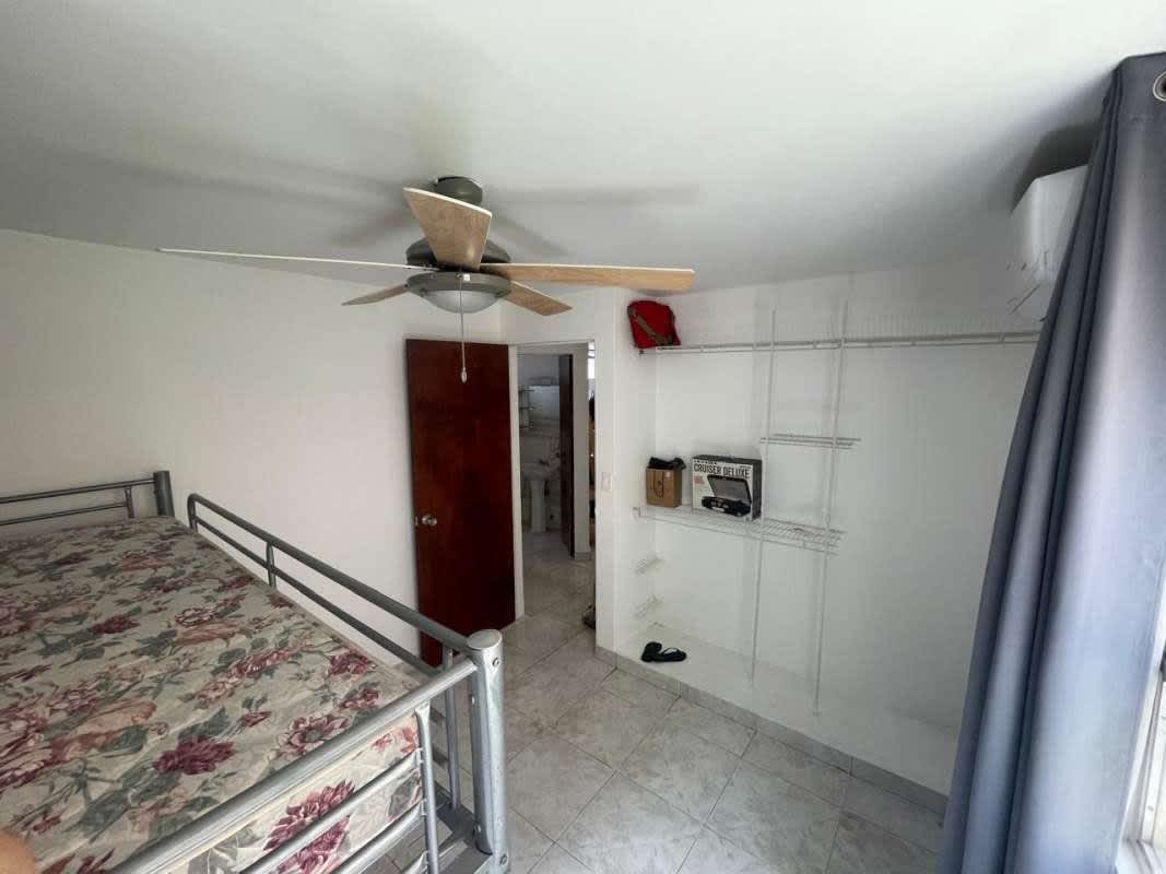 Peach-colored apartment building with balconies, gate, and landscaping in Villas El Carmen La Cresta Panama