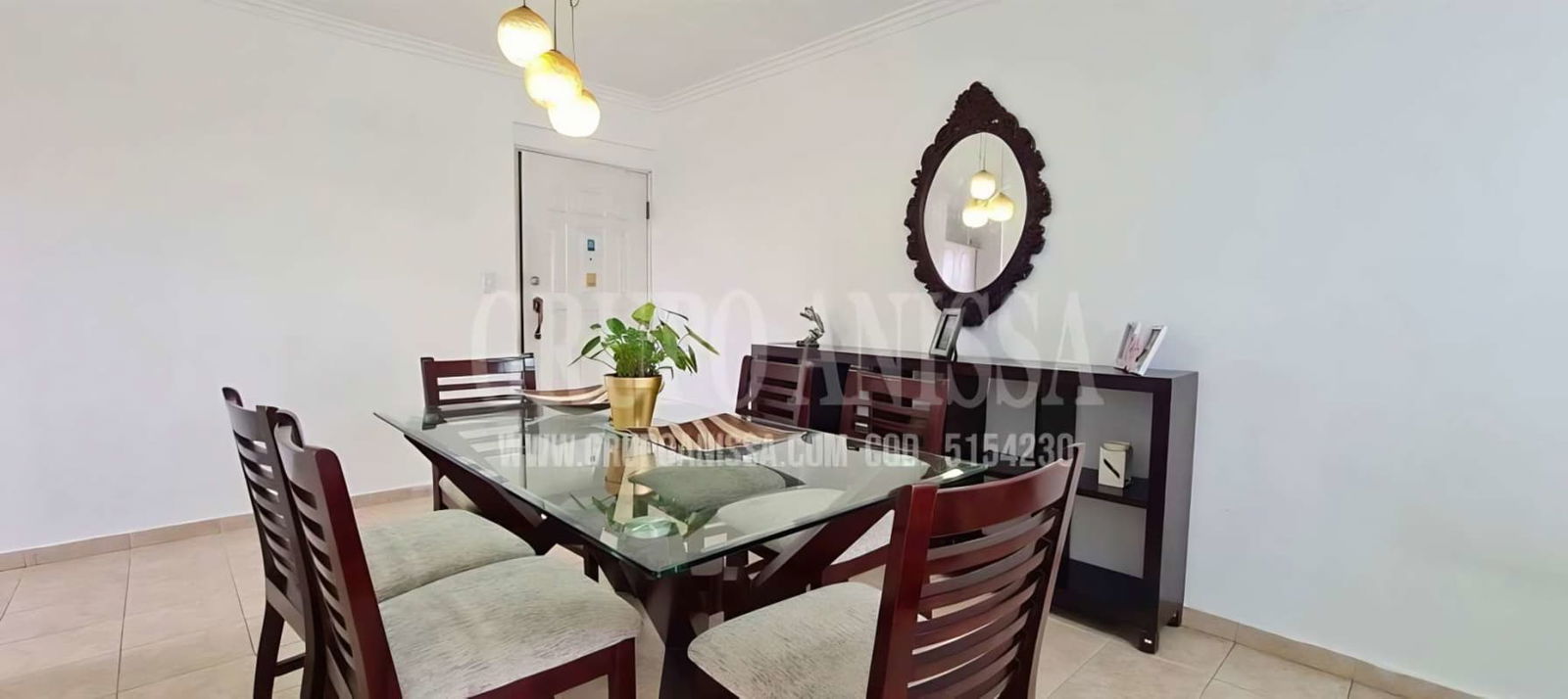 Glass dining table with hanging lights and decorative mirror in PH Villa de las Fuentes Panama City