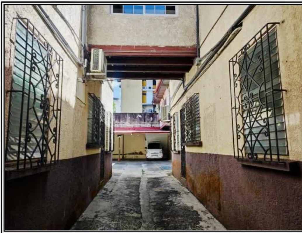 Covered outdoor parking next to mixed-use building Calidonia Perejil Panama City