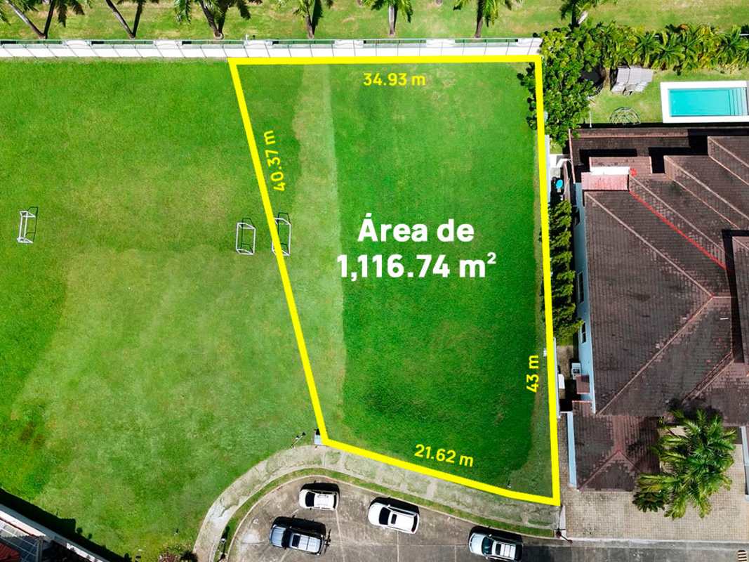 Green lot near soccer goals, residential houses and palm trees PH Veranda Panama
