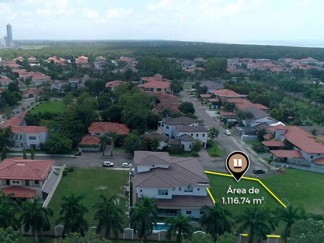 Empty corner lot aerial with luxury houses, city skyline background, golf views Panama City