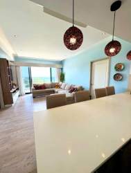 Modern living and dining area with ocean view balcony in Royal Palm Panama Pacifico
