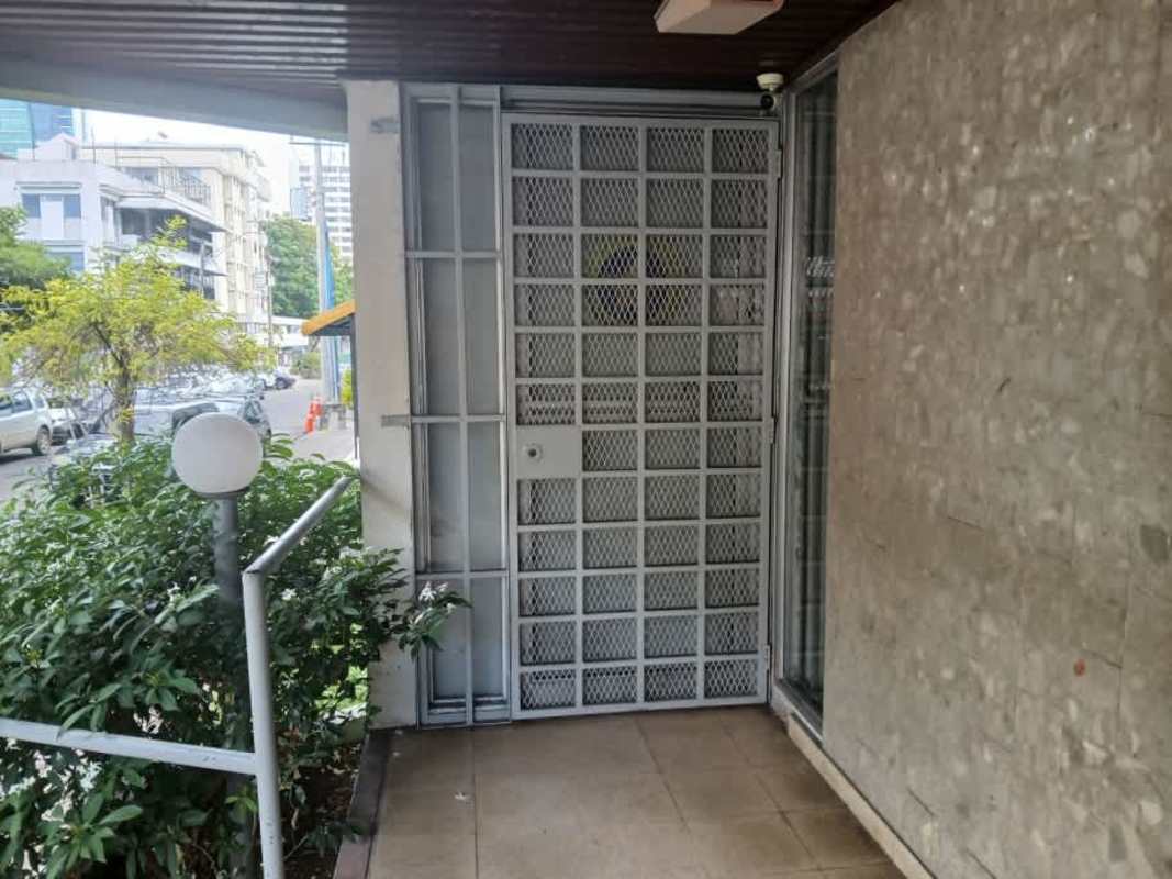 Exterior entrance with metal security gate, stone wall at Obarrio Business Plaza Panama