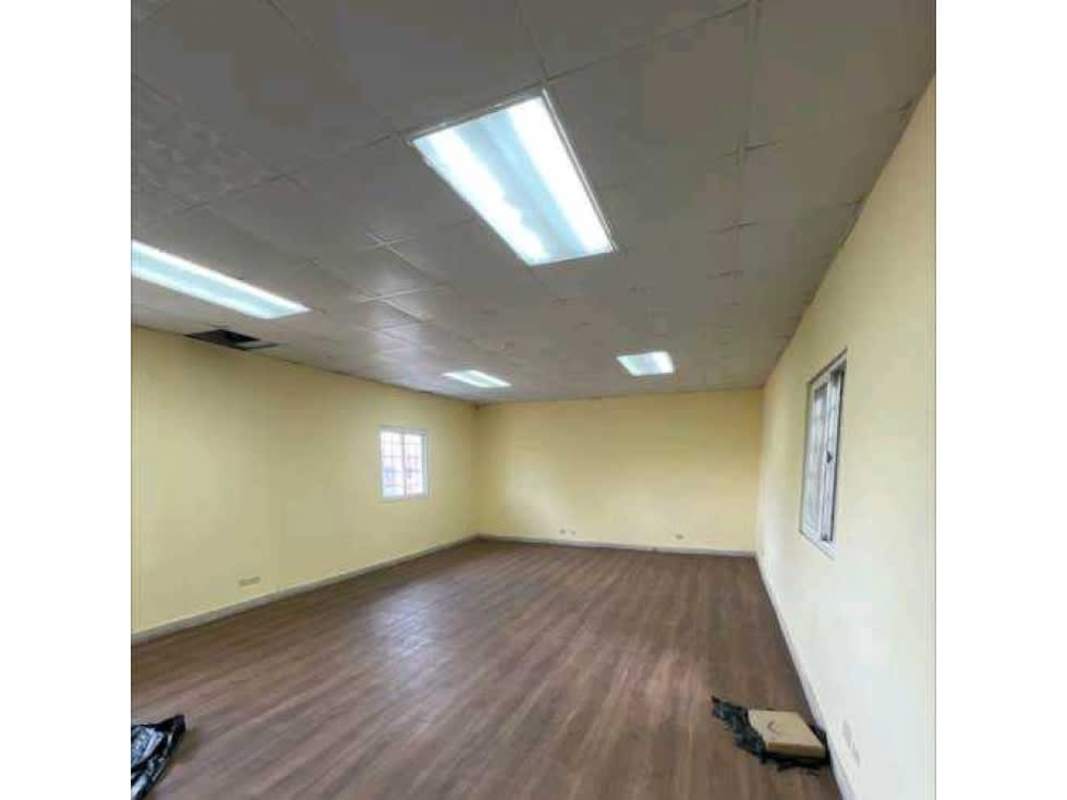 Multipurpose room with drop ceiling, fluorescent lights, windows, wood floors in warehouse building Panama
