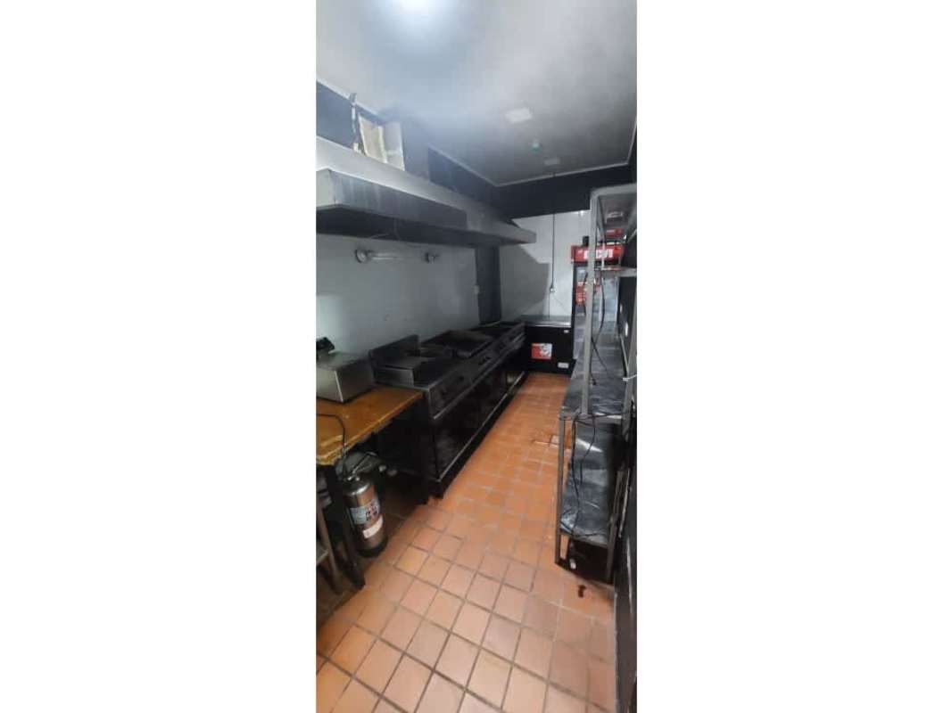 Commercial kitchen with cooking range, hood, metal shelves in restaurant space Plaza Triumph Bella Vista