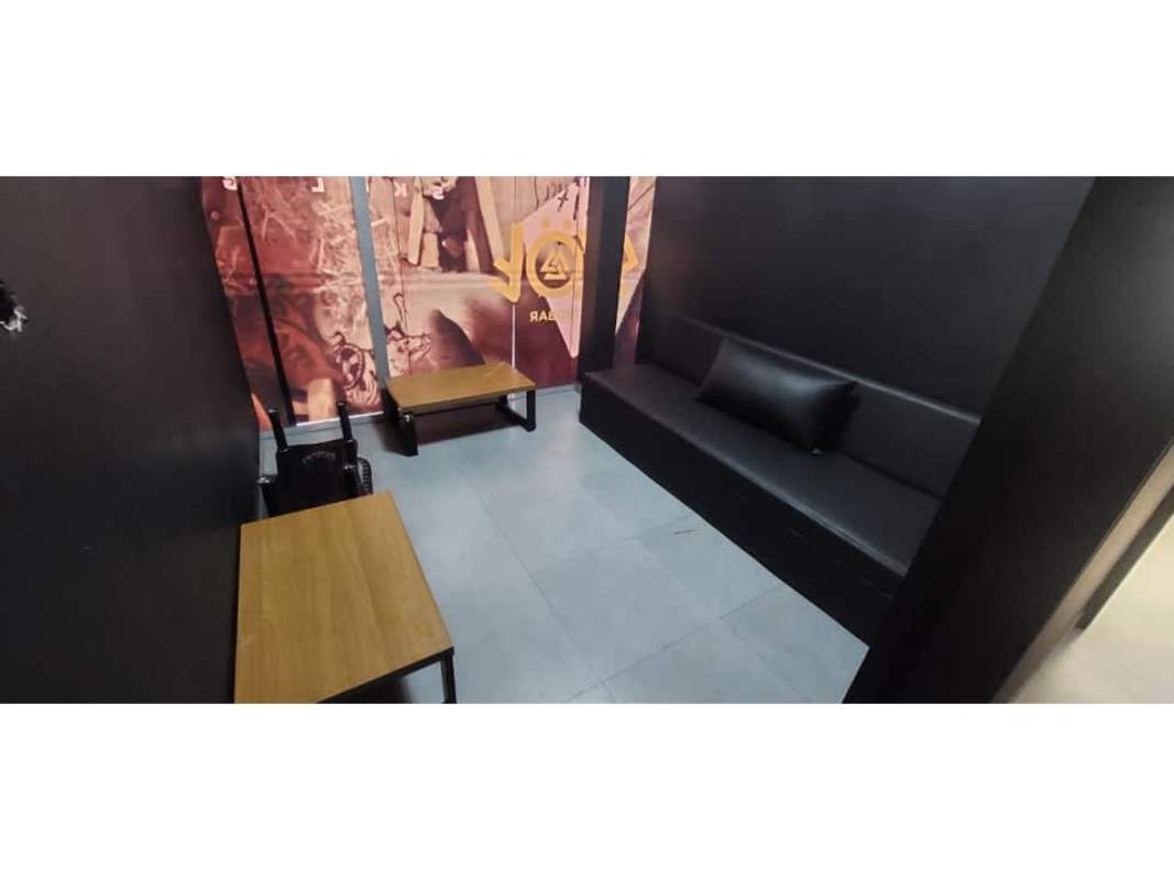 Modern commercial lounge area with black leather sofa, mural wall and tables at Plaza Triumph Panama
