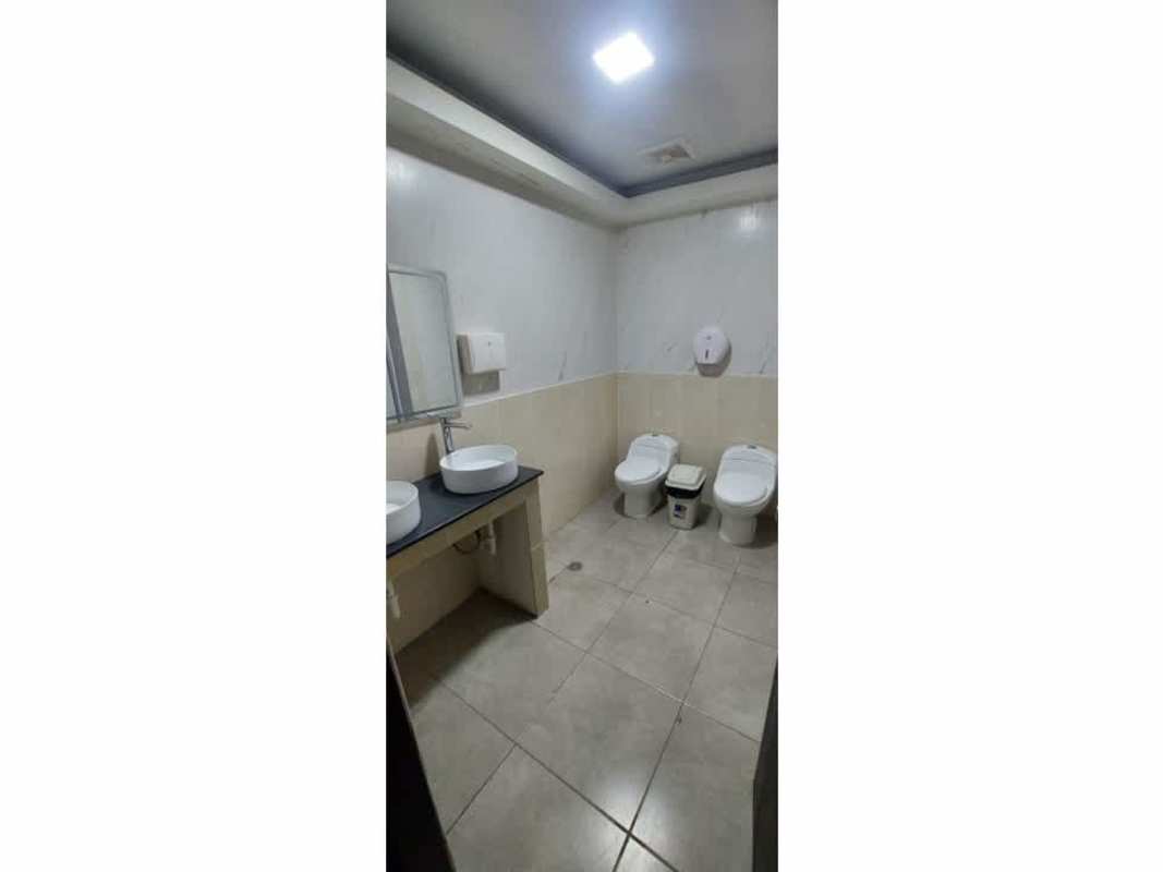 Modern commercial restroom with double sinks, two toilets, tiled floors in Plaza Triumph Calle Uruguay