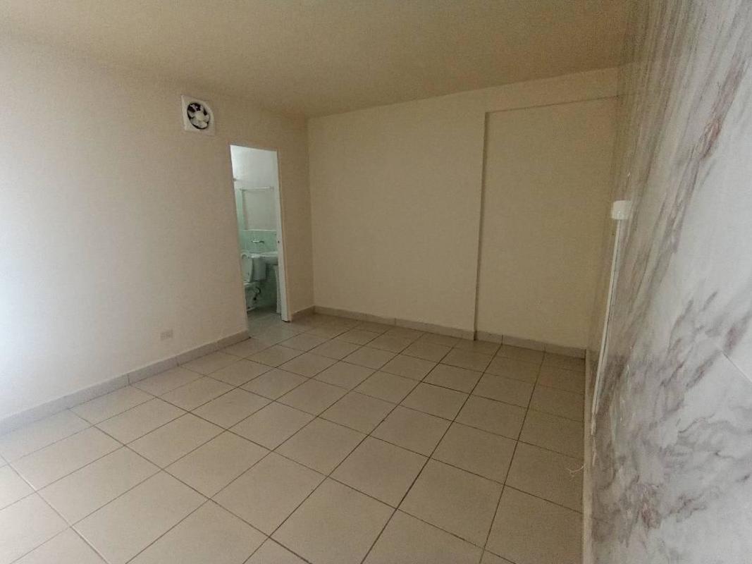 Spacious bedroom with built-in sliding door closet, louvered windows, ceramic tile flooring in rental apartment Rio Abajo Panama