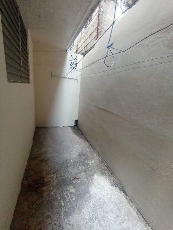 Minimal laundry room with utility sinks, light green backsplash, double louvered windows Panama City apartment rental