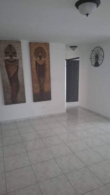 Empty living room with ceramic tiles, wall art decor, black door in PH Mirasol Panama