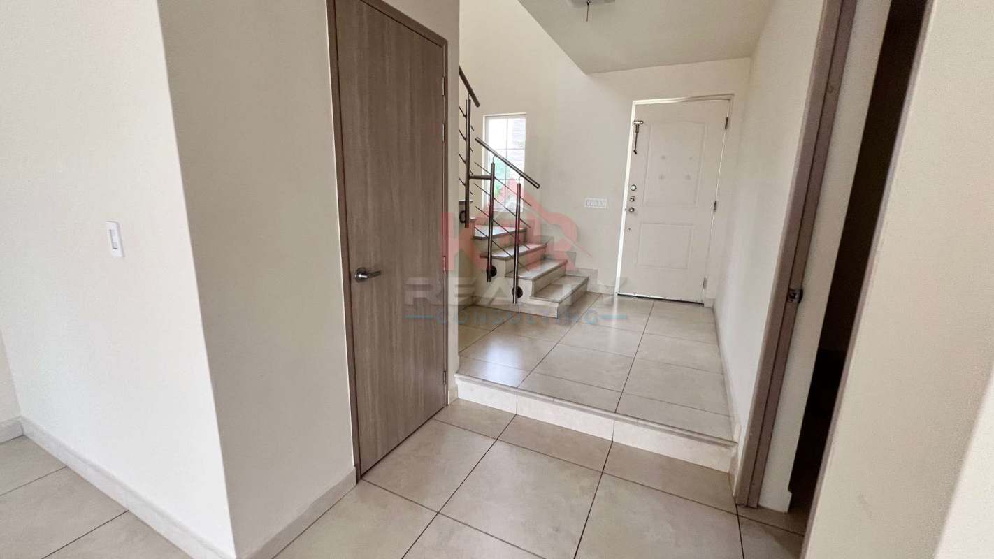 Modern interior entry hall with ceramic tile and metal rail staircase - Reserva de Versalles Panama