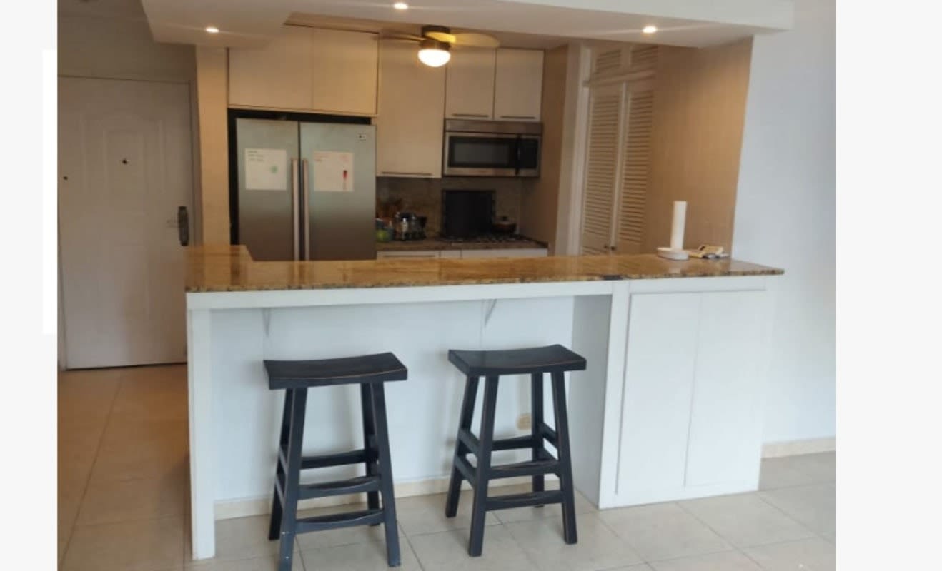 Kitchen with granite breakfast bar, refrigerator, microwave, gas stove PH Dos Mares Suites Panama