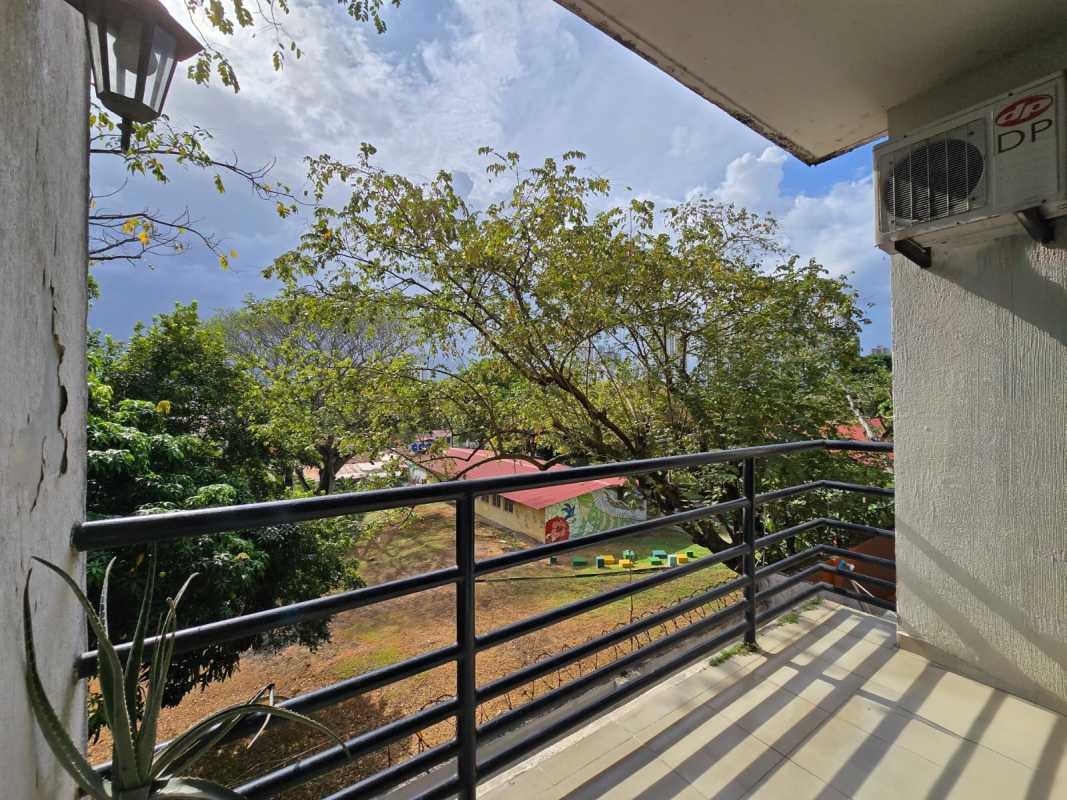 Small balcony with metal railing overlooking garden and playground PH Parque Miraflores Panama