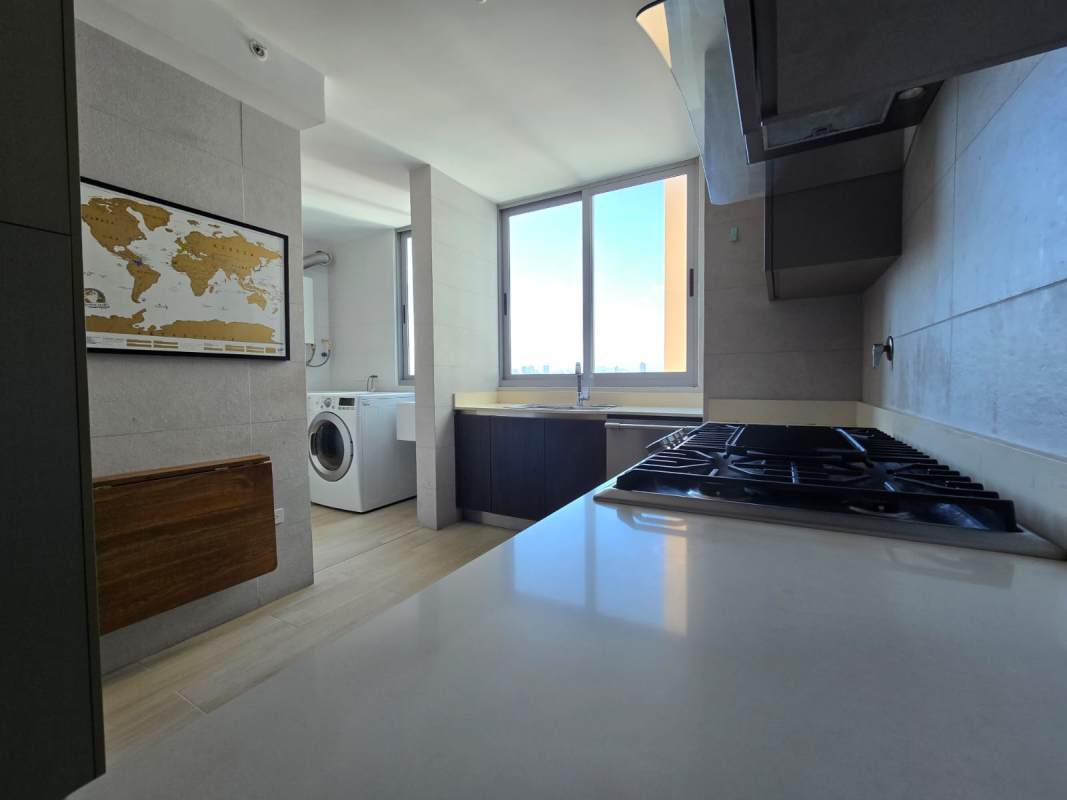 Modern kitchen with adjacent laundry, large window with city view PH Vita Coco del Mar Panama