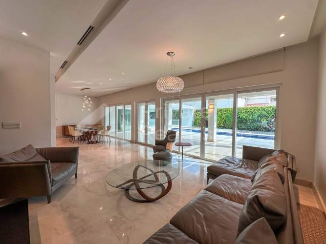 Double-height marble foyer with curved staircase chandelier and elegant design at Costa Las Perlas residence in Panama