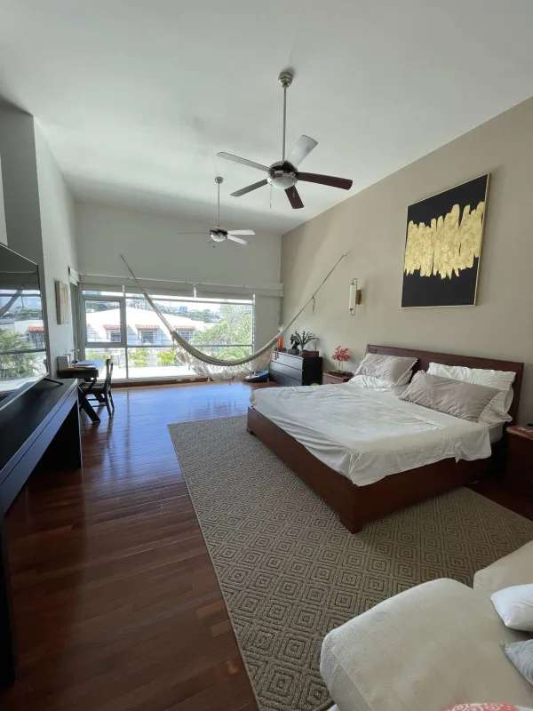 Elegant bedroom with vaulted high ceilings, wood floor, hammock and large windows in Altos del Golf Panama City