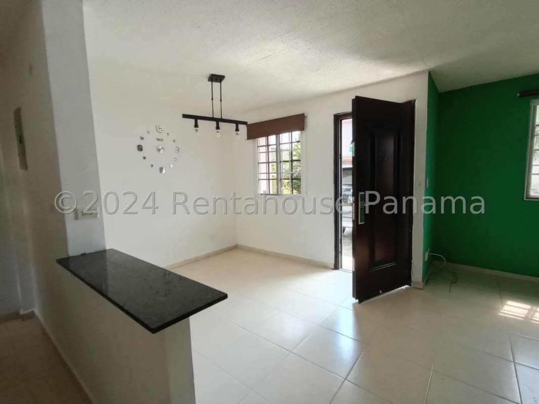 Compact kitchen with black granite countertop white cabinetry at PH Villas del Naranjal Pedregal Panama City