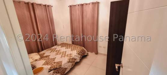 Bright bedroom with large window and tile floors in Residencial Playa San Carlos