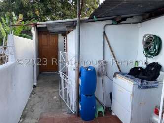 Outdoor laundry corner with barrels, cleaning tools, water storage in backyard La Chorrera