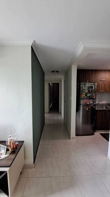 Hallway with crown molding leading to kitchen with refrigerator PH Mc Gregor Valley Panama City