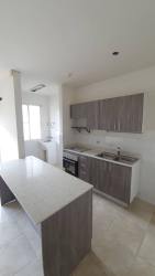 Compact kitchen with electric stove, cabinets, light countertops Playa Dorada Apartment Panama