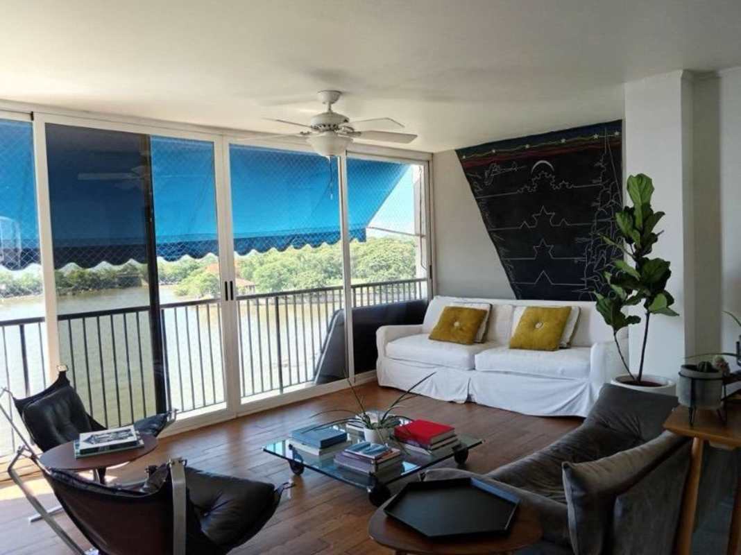 Enclosed balcony sunroom with glass doors, wood divider and blue awning at PH Las Llamas Panama City