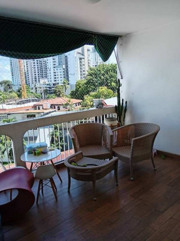 Open living-dining room with red sofa, glass table, balcony view in Coco del Mar PH Las Llamas