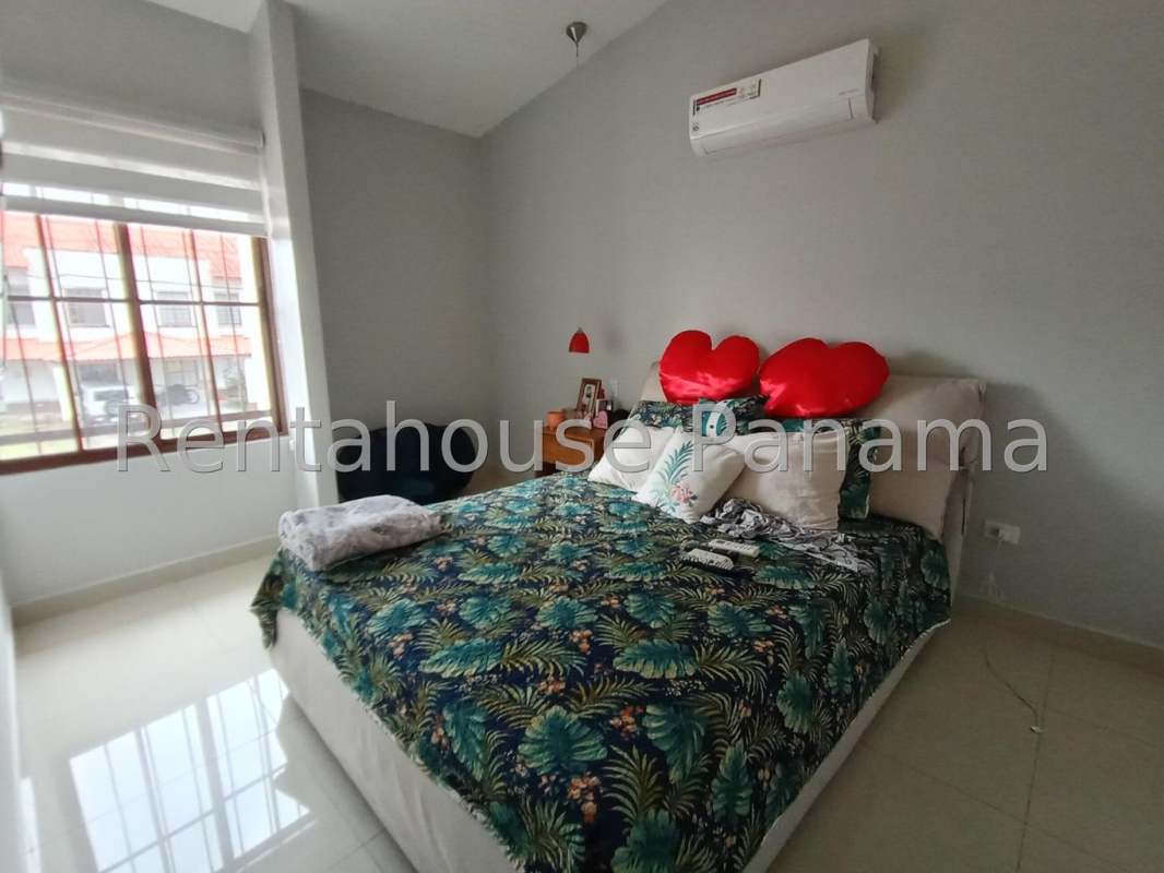 Bright bedroom with AC, large window with blinds, colorful bedding in Villa Zaita Panama