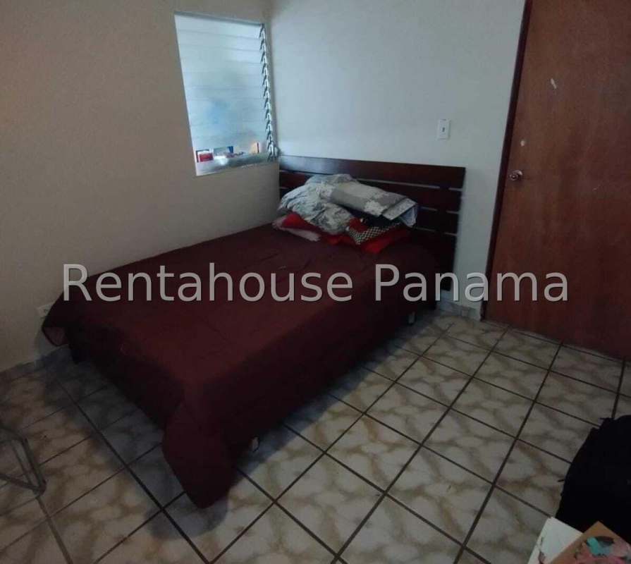 Bedroom with floral bedding, AC, window, tiled floors at PH José Eduardo Lefevre Panama