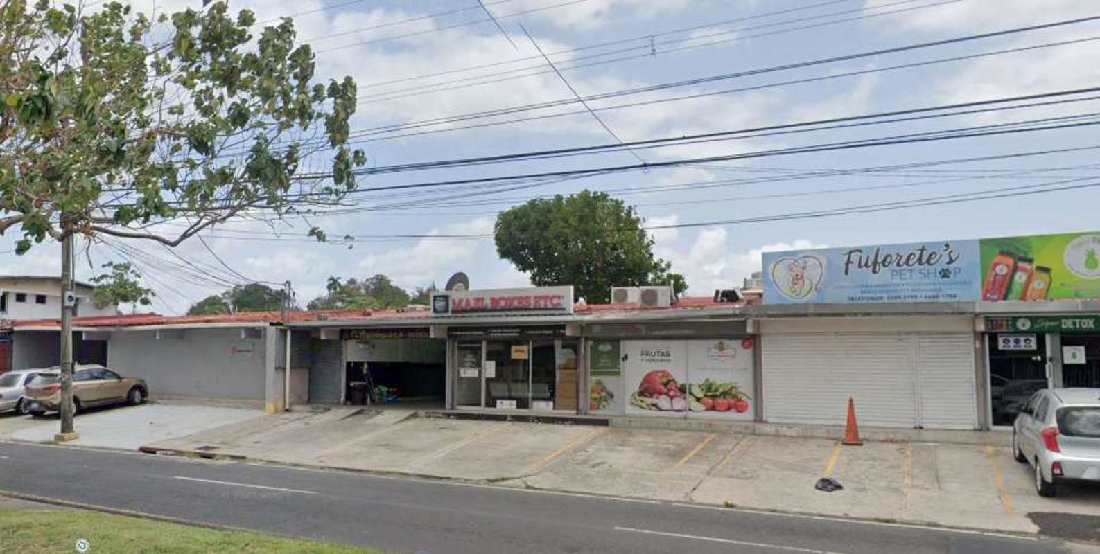 Multiple storefront commercial strip mall with signage areas and parking in Chanis Panama