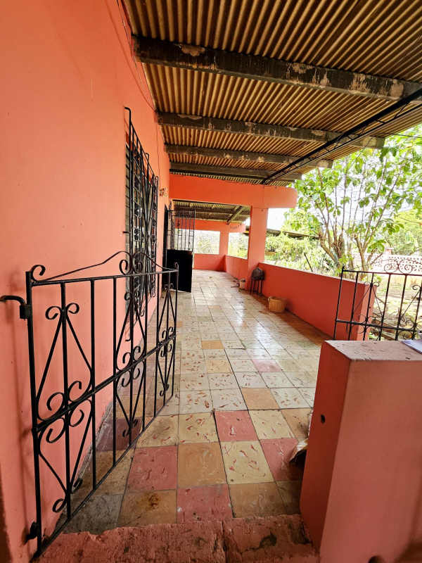 Bedroom with colorful tiles, ceiling fan, window with bars in Panama investment home