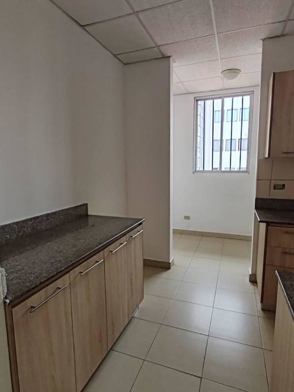 Apartment kitchen with granite counters, wooden cabinets and window PH El Ingenio Panama City