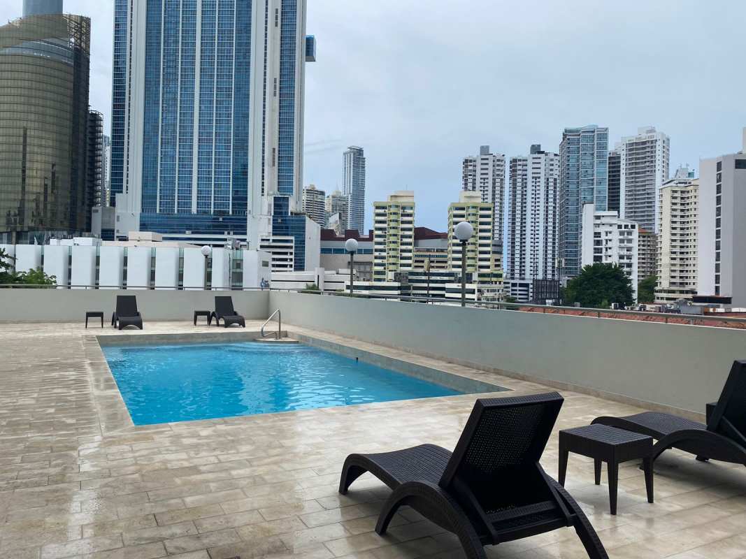 Elegant dining room with glass table and large mirror at PH Marsella in Marbella Panama City