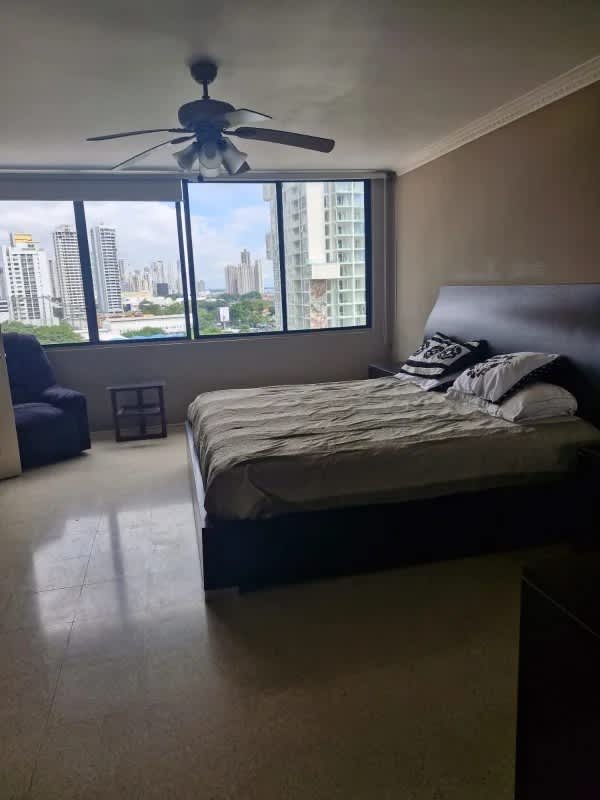 Spacious master bedroom with large window and Panama City skyline view at PH Marsella Marbella