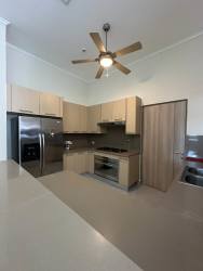 Bedroom with twin beds, neutral tones, ceiling fan, and garden views in Bijao Beach Condo