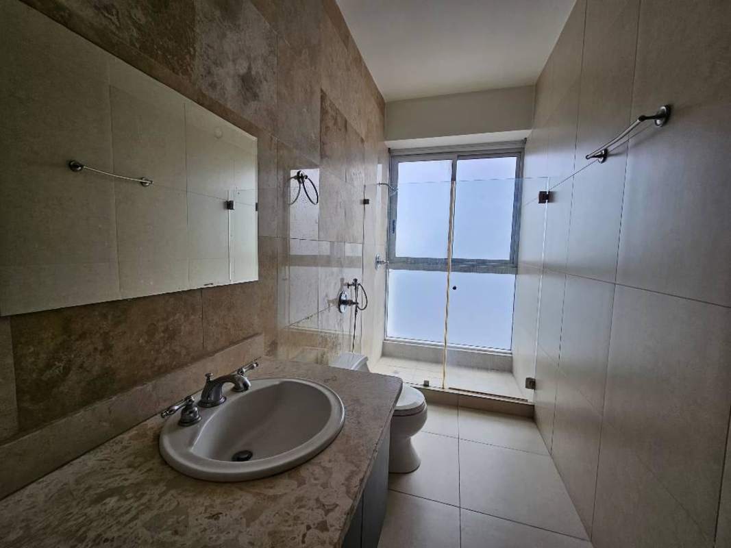 Elegant bathroom with glass shower and marble counter at PH Rivage Panama City