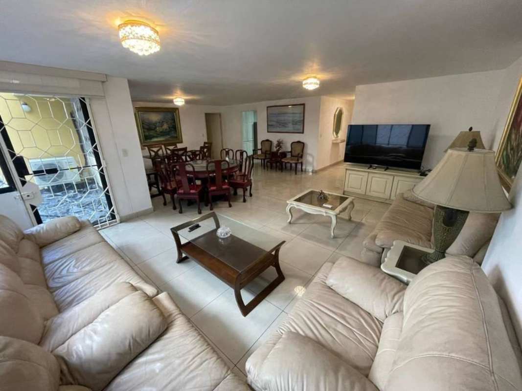 Open concept living dining with beige sofas and wooden table in PH Mónaco Obarrio Panama