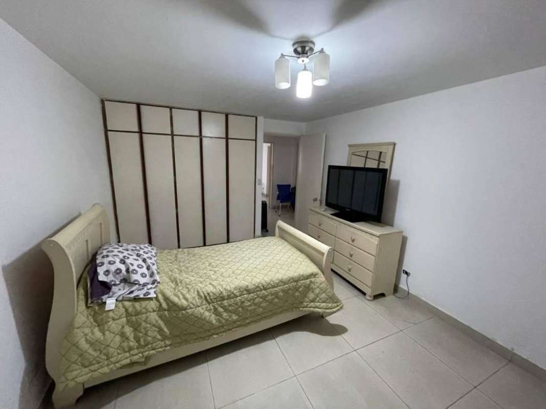 Spacious living and dining area with beige sofas, TV, and tiled floors in PH Mónaco Panama
