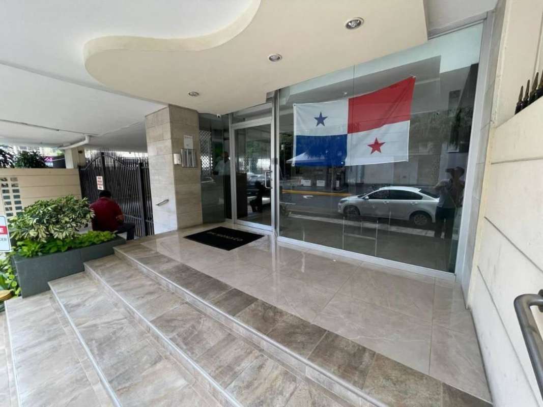 Modern apartment building entrance with glass doors at PH Mónaco Obarrio Panama