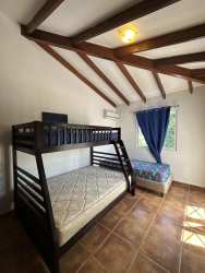 Bedroom with bunk bed, window blue curtain air conditioning Playa Blanca