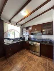 Dark wood kitchen cabinets, granite counter, exposed beams Playa Blanca beach house Panama