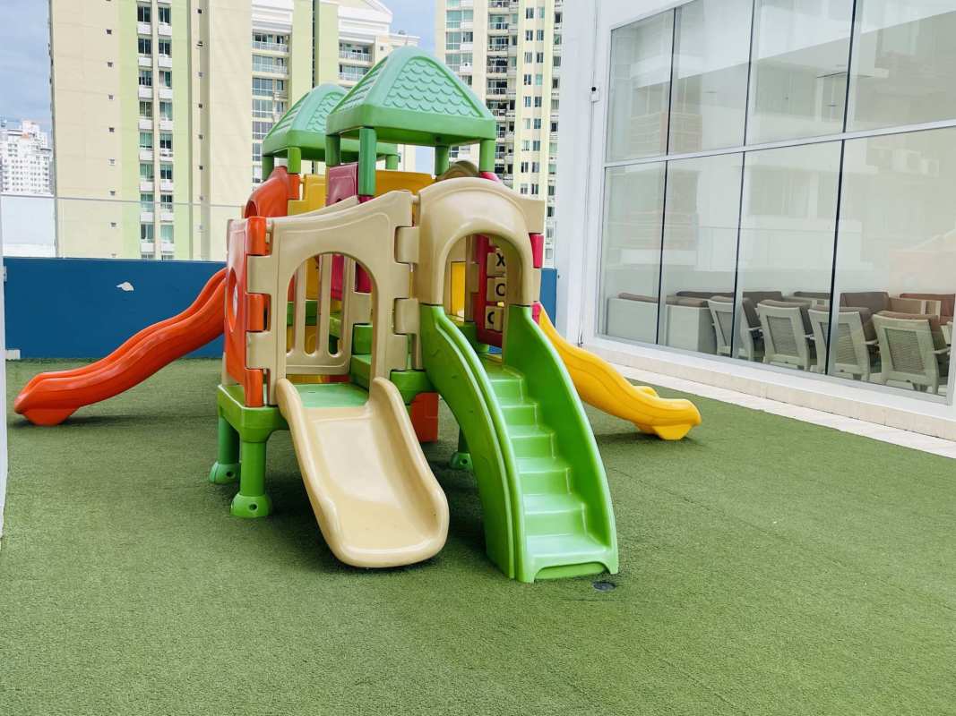Children's playground on rooftop with colorful slides and turf at PH Top Tower Costa del Este Panama