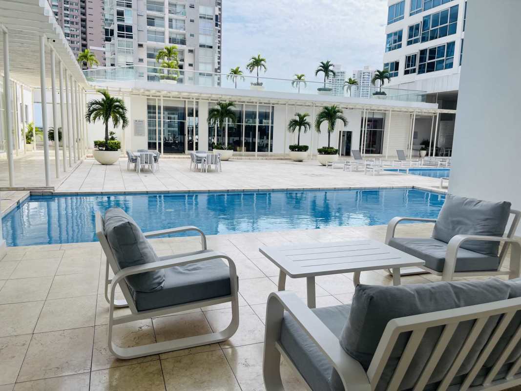 Infinity pool area with lounge chairs and skyline city views at PH Top Tower Costa del Este