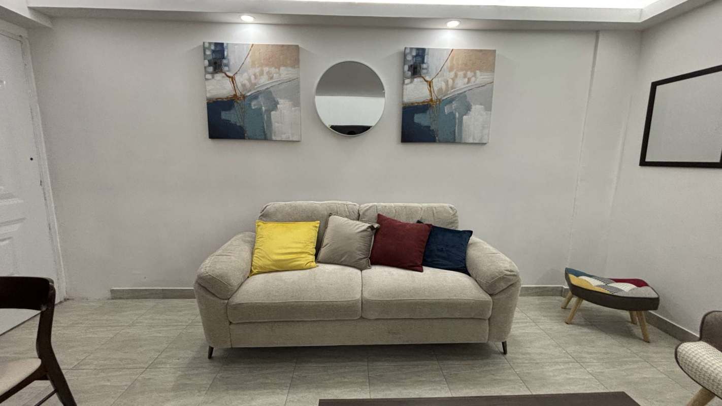 Bathroom with tiled walls, pedestal sink, striped curtain in PH Villa Lua Tocumen furnished apartment Panama